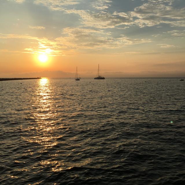 Vue sur la mer et les bateaux face au coucher de solei