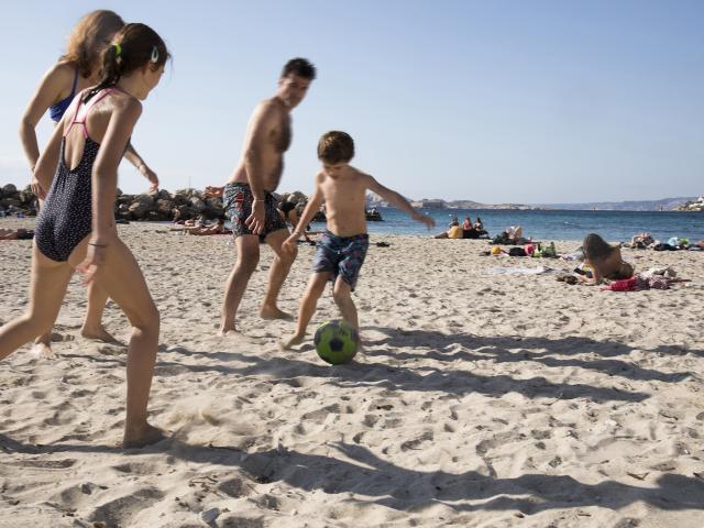famille qui joue au ballon sur la plage à Marseille