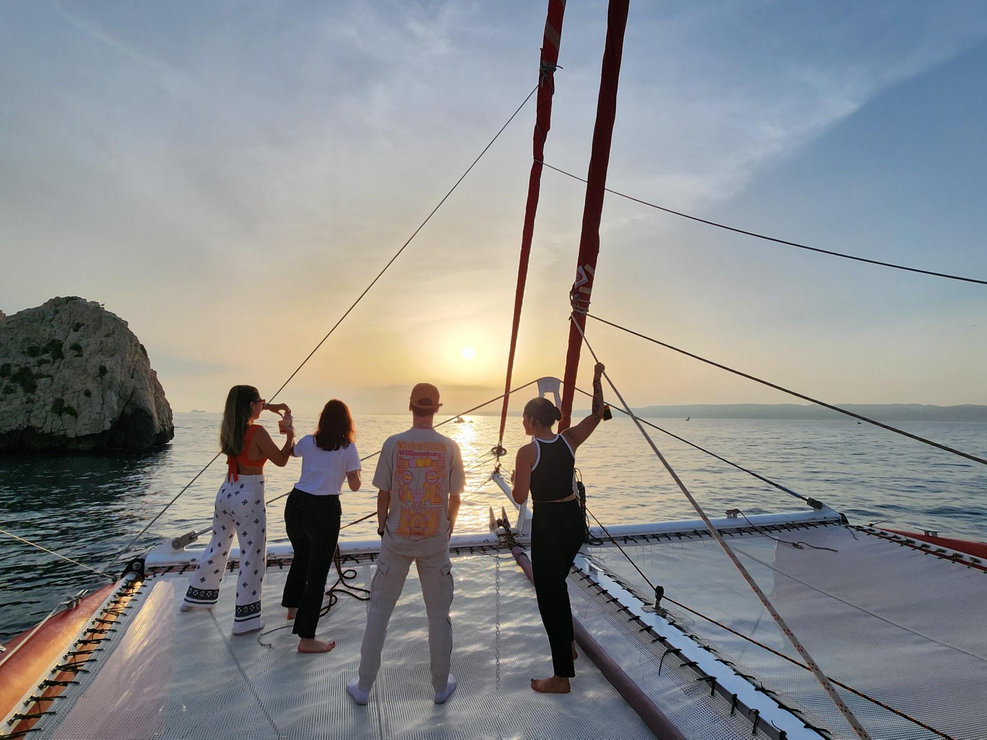 young people on a catamaran admiring the sunset off marseille