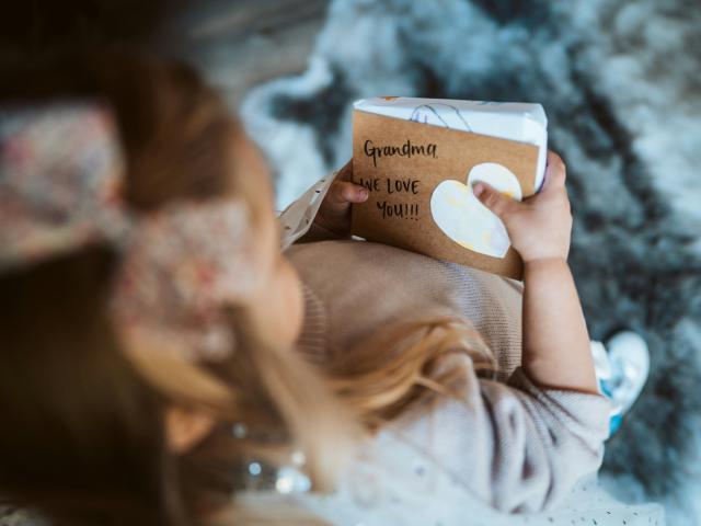 petite fille qui offre un cahier à sa grand mère