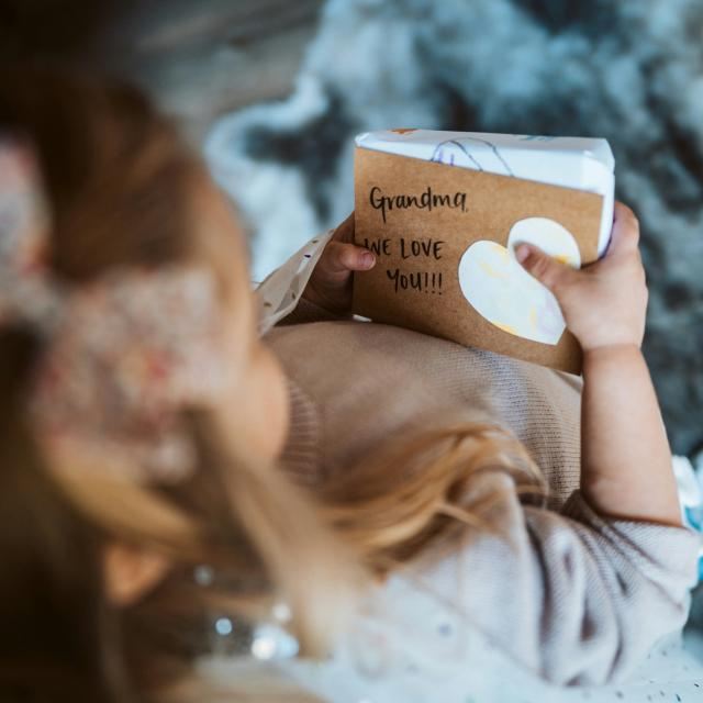 petite fille qui offre un cahier à sa grand mère